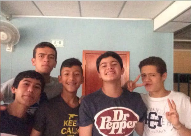 Original phone photo of five friends posing together indoors
