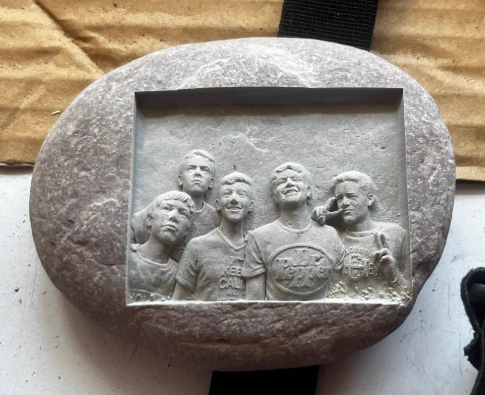 The finished natural stone with the five friends carved in bas-relief
