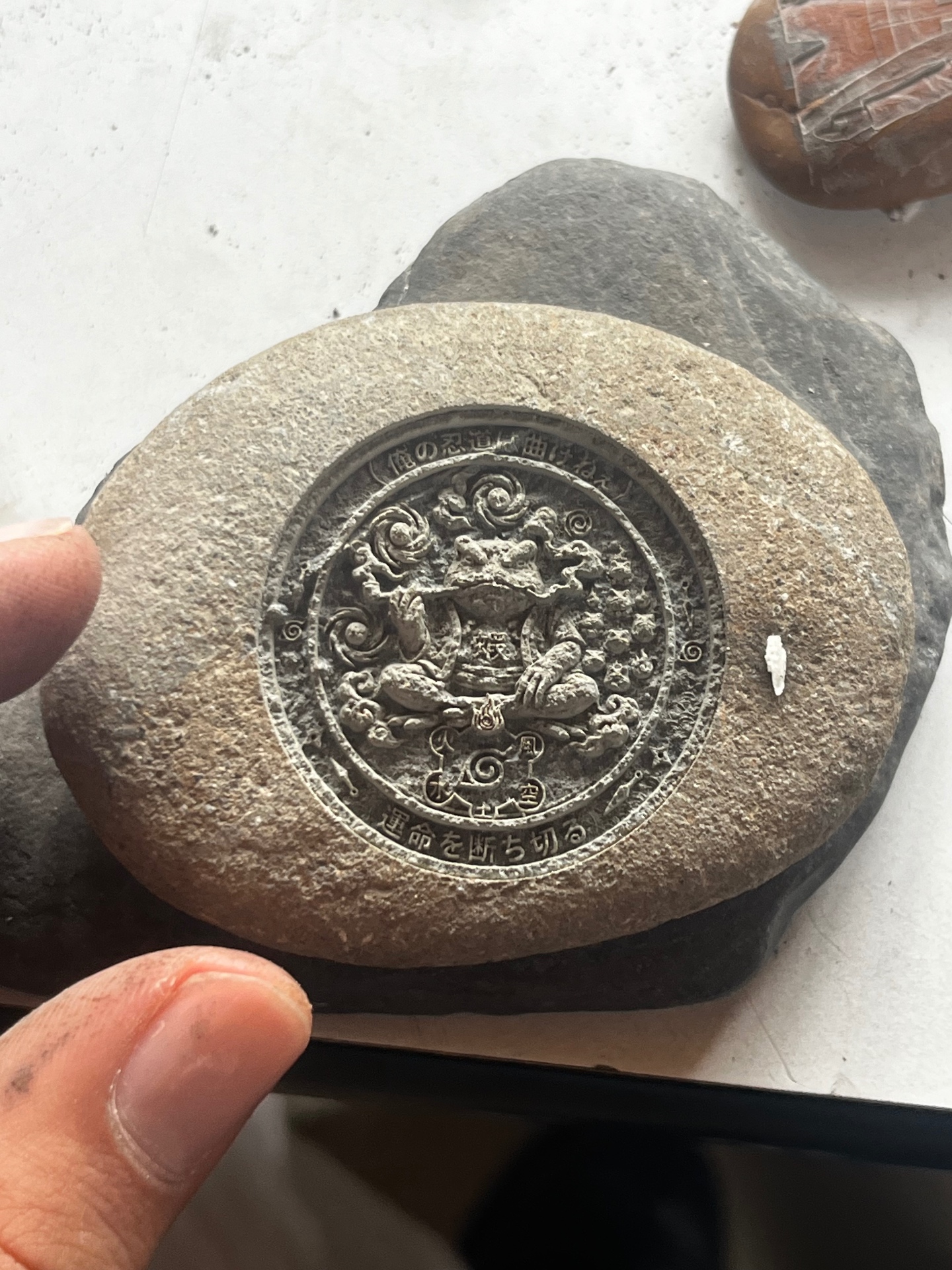 Mandala design engraved deep into a round grey natural stone